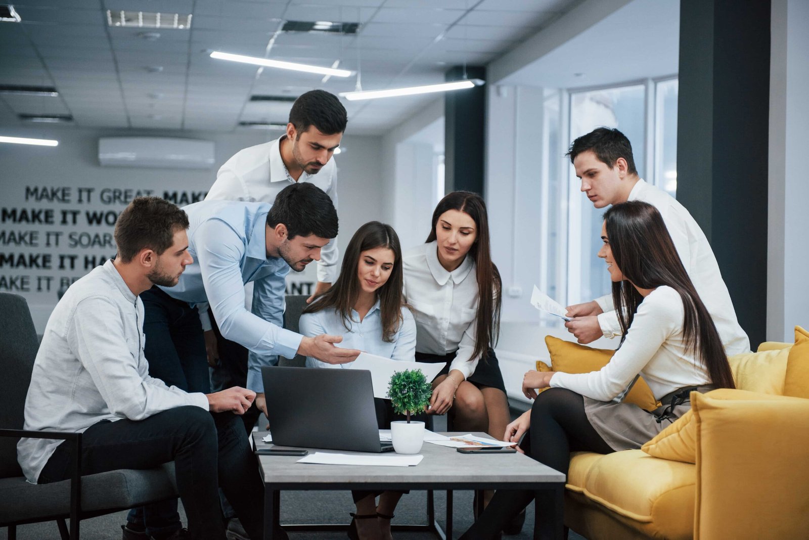 guy-shows-document-girl-group-young-freelancers-office-have-conversation-working-min-scaled